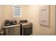 Modern laundry room with front loading washer and dryer, and a window at 2464 Ribbon Fall Ave, Davenport, FL 33837