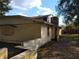 View of the side of the house with a retaining wall and boarded up windows at 2652 Ravenall Ave, Orlando, FL 32811