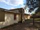 Side view of the home with a concrete block foundation and boarded up windows at 2652 Ravenall Ave, Orlando, FL 32811
