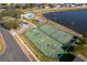 Aerial view showcasing the tennis and basketball courts with nearby street and lake at 2712 Pearl Court, Kissimmee, FL 34743