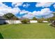 Large, well-maintained backyard featuring a white fence, mature trees, and a spacious lawn for recreation at 2712 Pearl Court, Kissimmee, FL 34743