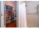 Bathroom featuring walk-in shower with a white shower curtain next to a walk-in closet with lots of clothing at 2712 Pearl Court, Kissimmee, FL 34743