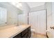 Clean bathroom with a dark vanity, a large mirror, and a shower with a white curtain, providing essential comfort at 2712 Pearl Court, Kissimmee, FL 34743