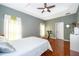 Cozy bedroom features wood flooring, a ceiling fan, and large windows providing natural light at 2712 Pearl Court, Kissimmee, FL 34743