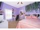 Bright bedroom featuring unique lilac walls, a charming desk, and a comfortable bed with a stylish headboard at 2712 Pearl Court, Kissimmee, FL 34743