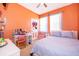Colorful bedroom with a comfy bed, a small desk, and bright orange walls, perfect for a or teen at 2712 Pearl Court, Kissimmee, FL 34743