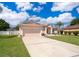Inviting single-story home with a two-car garage, well-maintained lawn, and a lengthy driveway under a partly cloudy sky at 2712 Pearl Court, Kissimmee, FL 34743