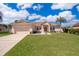 Charming single-story home featuring a well-manicured lawn, beautiful landscaping, and a spacious two-car garage at 2712 Pearl Court, Kissimmee, FL 34743