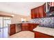 Well-lit kitchen features granite counters, stainless steel appliances, a tile backsplash and seamless access to the dining and living room at 2712 Pearl Court, Kissimmee, FL 34743