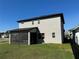 Back of house shows screened in patio with ample yard space and black fence for privacy at 2861 Willowseed Ln, St Cloud, FL 34772