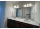Bathroom with double sinks, large mirrors, dark cabinets, and bright vanity lighting at 2861 Willowseed Ln, St Cloud, FL 34772