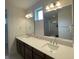 Bathroom with double sinks, dark cabinets, large mirrors, and modern lighting at 2861 Willowseed Ln, St Cloud, FL 34772