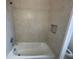 Close up of bathtub and tiling shower in a neutral-colored bathroom at 2861 Willowseed Ln, St Cloud, FL 34772