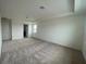 Spacious bedroom with neutral carpet, tray ceiling, and ample natural light at 2861 Willowseed Ln, St Cloud, FL 34772