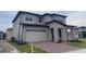 Two-story home featuring a brick paver driveway, two car garage and neutral stucco exterior at 2861 Willowseed Ln, St Cloud, FL 34772