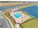 Aerial view of a community pool with ample seating and a covered pavilion overlooking a lake at 2861 Willowseed Ln, St Cloud, FL 34772