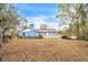 A wide shot of the back of the home, showing the large backyard and an older tractor at 2935 Apaloosa Trl, Deltona, FL 32738