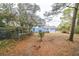 View of the backyard and blue home with mature trees, shed, and tractor at 2935 Apaloosa Trl, Deltona, FL 32738