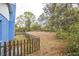 Spacious backyard with wooden fence, mature trees, and tractor in the distance at 2935 Apaloosa Trl, Deltona, FL 32738