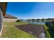 Spacious backyard with a peaceful lake view, a fenced perimeter, and fresh grass at 3018 Jardin St, Kissimmee, FL 34741