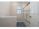 Bright bathroom featuring tile walls, a shower with sliding glass doors, and a window with blinds at 3018 Jardin St, Kissimmee, FL 34741