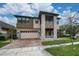 Beautiful two-story home with stone accents, a screened balcony, a paver driveway, and a two car garage at 3018 Jardin St, Kissimmee, FL 34741