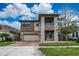 Beautiful two-story home with stone accents, a screened balcony, a paver driveway, and a two car garage at 3018 Jardin St, Kissimmee, FL 34741