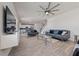 Spacious living room featuring modern furnishings, a ceiling fan, and open access to the kitchen at 3018 Jardin St, Kissimmee, FL 34741