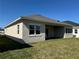 Exterior rear view of a home featuring a covered patio and a well-manicured green lawn at 3108 Firethorn Cir, Daytona Beach, FL 32124