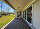 Covered patio featuring brick pavers and sliding glass doors to the home's interior with views of the landscaped backyard at 3108 Firethorn Cir, Daytona Beach, FL 32124