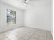 Bright bedroom featuring tile floors, a ceiling fan, and a window that fills the space with natural light at 3141 Wainwright St, Deltona, FL 32738
