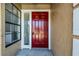 Close-up on a striking red front door flanked by a window, highlighting the home's inviting entryway and design at 3141 Wainwright St, Deltona, FL 32738