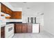 A view of kitchen featuring tile floors, wood cabinets, and white appliances at 3141 Wainwright St, Deltona, FL 32738