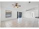 Open-concept living area with tile flooring, a ceiling fan, and large windows, creating an inviting and airy atmosphere at 3141 Wainwright St, Deltona, FL 32738