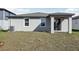 Backyard view of the home with sliding glass doors leading to covered patio and a grassy lawn at 317 Castle Dr, Lake Alfred, FL 33850