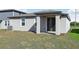 Exterior of the home showcasing a covered patio and well-maintained lawn at 317 Castle Dr, Lake Alfred, FL 33850