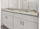 Modern bathroom with dual sinks, granite countertops, and sleek white cabinetry at 317 Castle Dr, Lake Alfred, FL 33850