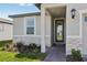 Inviting front porch with a glass door, stone accents, and a well-maintained landscape at 317 Castle Dr, Lake Alfred, FL 33850