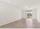 Bright living room with sliding glass doors to backyard, neutral paint, and tile flooring at 317 Castle Dr, Lake Alfred, FL 33850