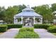 Community white gazebo surrounded by lush landscaping and a paved walkway on a cloudy day at 3291 Westchester Square Blvd # 203, Orlando, FL 32835