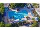 Aerial view of a large community pool with blue lounge chairs and sun umbrellas on a sunny day at 3291 Westchester Square Blvd # 203, Orlando, FL 32835