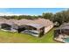 Aerial perspective of home with a screened pool enclosure, backyard seating, and mature trees at 417 Calabay Parc Blvd, Davenport, FL 33897