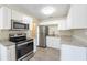 Updated kitchen features stainless steel appliances and white cabinets against a neutral wall color at 4192 Gallimore St, Orlando, FL 32811