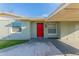 Inviting front entrance with a vibrant red door, windows, and well-manicured greenery at 4489 Prince Hall Blvd, Orlando, FL 32811