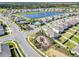 An aerial view of a playground, swimming pool, lake, and rows of houses in a lovely community at 493 Talisi Loop, St Cloud, FL 34771