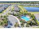 Aerial view of the community pool surrounded by palm trees and a lake at 493 Talisi Loop, St Cloud, FL 34771
