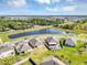 Aerial shot featuring backyards of well-kept homes next to a pond and natural wooded area at 493 Talisi Loop, St Cloud, FL 34771