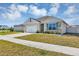 Well-manicured lawn leads up to the home with a two-car garage and a front door with decorative wreath at 493 Talisi Loop, St Cloud, FL 34771