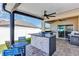 Covered outdoor kitchen featuring a grill, granite countertop, and bar seating, perfect for al fresco dining at 493 Talisi Loop, St Cloud, FL 34771