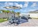 Backyard patio featuring outdoor table, hot tub, and sun umbrella at 493 Talisi Loop, St Cloud, FL 34771